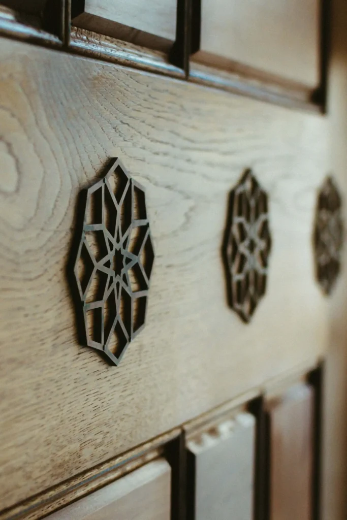 Close-up of a wooden door featuring decorative star-shaped carvings set in a vertical row.