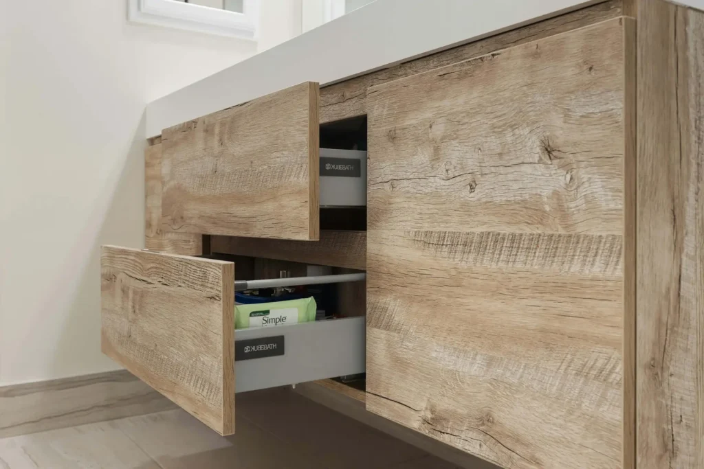 Wooden bathroom cabinet with two drawers slightly open, revealing toiletries inside.