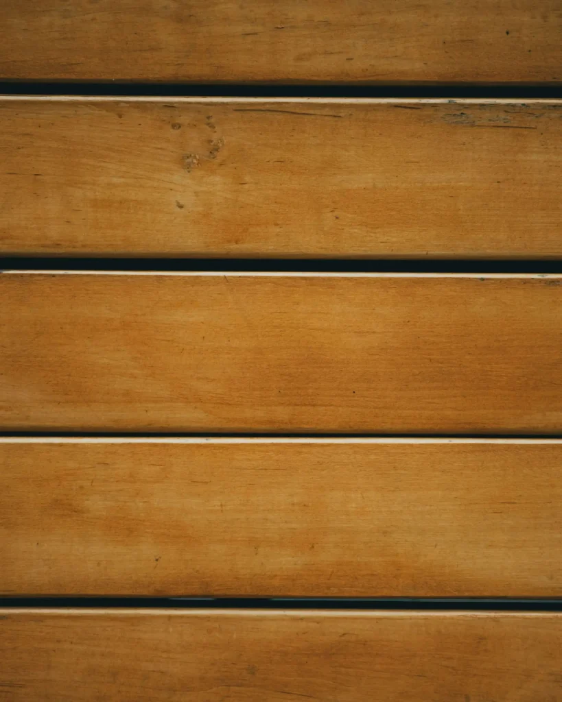 Close-up of wooden planks arranged horizontally, showing natural grain and varying shades of brown.